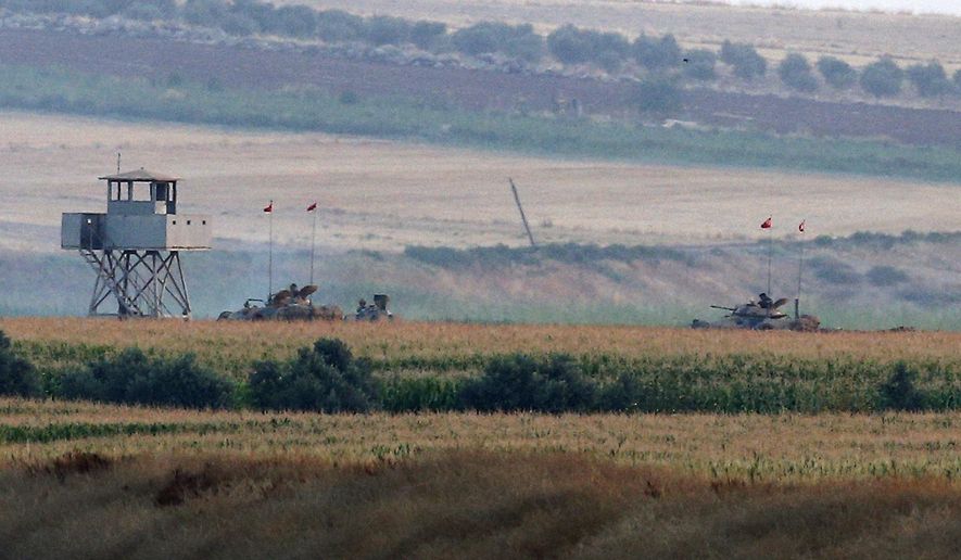 Turkish army tanks hold positions near the border with Syria, in the outskirts of the village of Elbeyi, east of the town of Kilis, in southeaster Turkey, Thursday, July 23, 2015. Suspected Islamic State militants fired at a Turkish military outpost from a region under IS control, inside Syrian territory Thursday, killing a Turkish soldier and wounding two others, an official said. Turkish troops retaliated to the attack and at least one IS militant was killed, amid a surge of violence in Turkey following a suicide bomb attack near Turkey&#39;s border with Syria which killed 32 people. (AP Photo/Emrah Gurel)