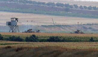 Turkish army tanks hold positions near the border with Syria, in the outskirts of the village of Elbeyi, east of the town of Kilis, in southeaster Turkey, Thursday, July 23, 2015. Suspected Islamic State militants fired at a Turkish military outpost from a region under IS control, inside Syrian territory Thursday, killing a Turkish soldier and wounding two others, an official said. Turkish troops retaliated to the attack and at least one IS militant was killed, amid a surge of violence in Turkey following a suicide bomb attack near Turkey&#39;s border with Syria which killed 32 people. (AP Photo/Emrah Gurel)