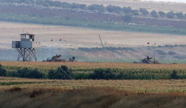 Turkish army tanks hold positions near the border with Syria, in the outskirts of the village of Elbeyi, east of the town of Kilis, in southeaster Turkey, Thursday, July 23, 2015. Suspected Islamic State militants fired at a Turkish military outpost from a region under IS control, inside Syrian territory Thursday, killing a Turkish soldier and wounding two others, an official said. Turkish troops retaliated to the attack and at least one IS militant was killed, amid a surge of violence in Turkey following a suicide bomb attack near Turkey&#x27;s border with Syria which killed 32 people. (AP Photo/Emrah Gurel)