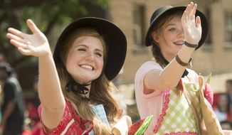 In this July 24, 2014, photo, Marin Allen and Ashlyn Bunker participate in the Days of 47 Pioneer Parade in Salt Lake City. Each year on July 24, Mormons take off work to gather at festive parades celebrating their heritage on Pioneer Day. Non-Mormons have invented their own counter-holiday around pies and beer. (AP Photo/The Salt Lake Tribune, Rick Egan)