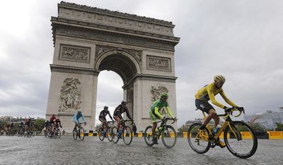 Britain&#39;s Chris Froome, right, wearing the overall leader&#39;s yellow jersey cycles past the Arc de Triomphe during the twenty-first and last stage of the Tour de France cycling race over 109.5 kilometers (68 miles) with start in Sevres and finish in Paris, France, Sunday, July 26, 2015. (AP Photo/Laurent Cipriani)
