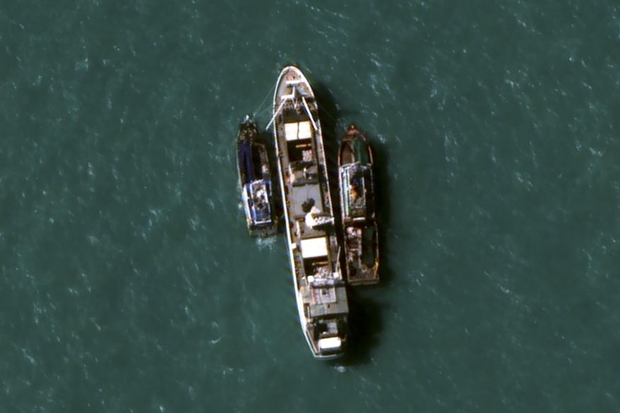 In this July 14, 2015, image provided by DigitalGlobe, a high-resolution satellite photograph off the coast of Papua New Guinea shows two fishing trawlers loading slave-caught fish onto Silver Sea 2, a refrigerated cargo ship belonging to the Thai-owned Silver Sea Fishery Co. The company was named in an Associated Press investigation into slavery in Southeast Asia’s seafood industry that led to the rescue and repatriation of more than 800 men. Hundreds more remain missing after their trawlers fled an Indonesian crackdown on illegal fishing. (DigitalGlobe via AP)