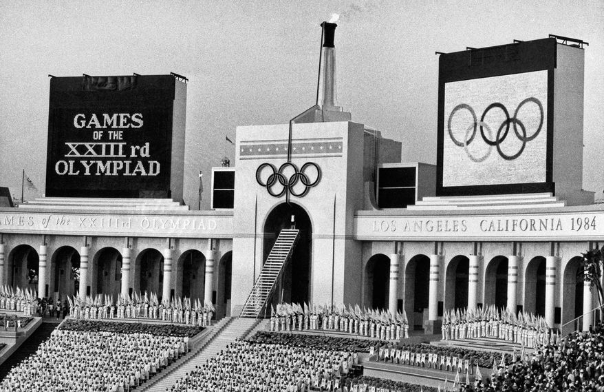 FILE - In this July 28, 1984, file photo, the Olympic flame is flanked by a scoreboard signifying the formal opening of the XXIII Olympiad after it was lit by Rafer Johnson during the opening ceremonies in the Los Angeles Memorial Coliseum. Embarrassing as it was, the U.S. Olympic Committee won’t necessarily be remembered for its ungainly dumping of Boston as a bid city for the 2024 Olympics. The USOC has seven weeks to get another city on board _ and it could be Los Angeles. (AP Photo/Eric Risberg, File)