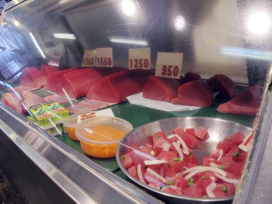In this July 14, 2015 photo, bigeye tuna lines a fish market counter in Honolulu. Hawaii’s longline fishermen are on course to hit their annual bigeye tuna catch limit next week, three months earlier than last year, which means they'll have to stop catching bigeye in their most productive fishing grounds west of Hawaii on Aug. 5. (AP Photo/Audrey McAvoy)
