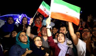 Jubilant Iranians sang and waved Iranian flags during street celebrations in Tehran after a landmark nuclear deal. Many of the country&#39;s sidelined reformist politicians and human rights activists are quietly greeting the pact with support. (Associated Press)