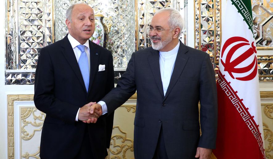 Iranian Foreign Minister Mohammad Javad Zarif, right, and his French counterpart Laurent Fabius shake hands for media prior to their round of talks in Tehran, Iran, Wednesday, July 29, 2015. Iran&#39;s state media say French Foreign Minister Laurent Fabius&#39;s visit to Iran is the start of a &#39;new era&#39; in bilateral relations following a historic nuclear deal with world powers earlier this month. Fabius said Wednesday the time has come for Iran and France to warm up their relations, calling his visit &amp;quot;an important trip.&amp;quot;(AP Photo/Ebrahim Noroozi)