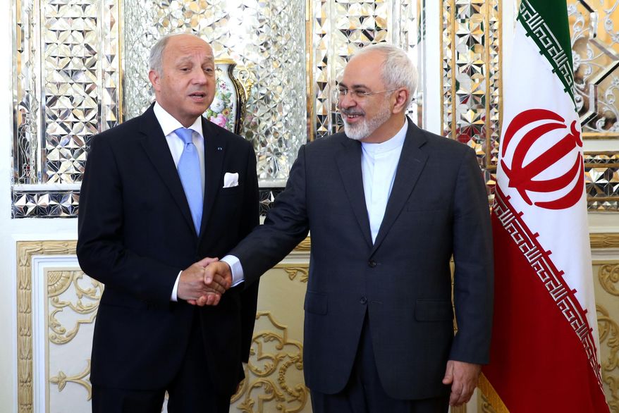 Iranian Foreign Minister Mohammad Javad Zarif, right, and his French counterpart Laurent Fabius shake hands for media prior to their round of talks in Tehran, Iran, Wednesday, July 29, 2015. Iran's state media say French Foreign Minister Laurent Fabius's visit to Iran is the start of a 'new era' in bilateral relations following a historic nuclear deal with world powers earlier this month. Fabius said Wednesday the time has come for Iran and France to warm up their relations, calling his visit "an important trip."(AP Photo/Ebrahim Noroozi)