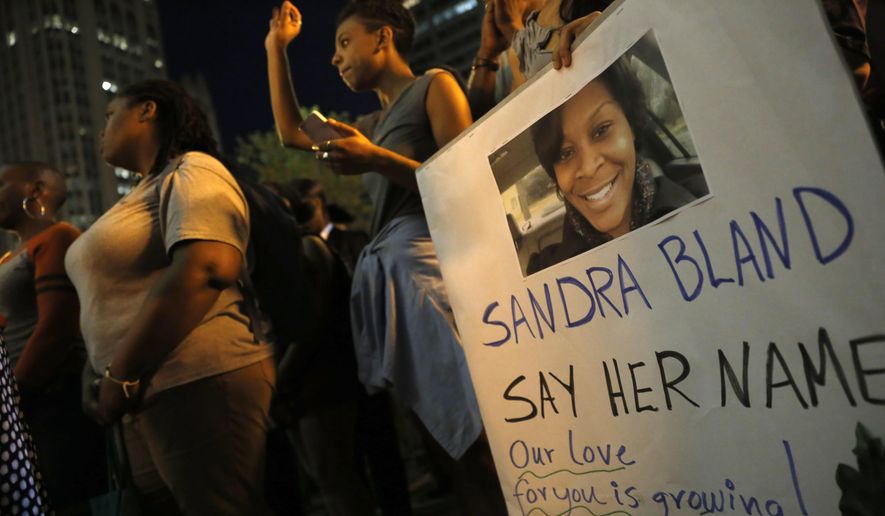 A demonstrator holds a Sandra Bland sign during a vigil, Tuesday evening, July 28, 2015, near the DuSable Bridge on Michigan Ave. in Chicago. Bland died in a Texas county jail after the traffic stop for failing to use a turn signal escalated into a physical confrontation. Authorities have said Bland hanged herself, a finding her family disputes. The death has garnered national attention amid increased scrutiny of police treatment of blacks in the wake of several high-profile police-involved deaths. (AP Photo/Christian K. Lee) ** FILE **