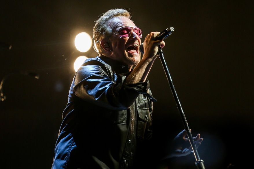 In this May 26, 2015 photo, Bono of U2 performs at the Innocence + Experience Tour at The Forum in Inglewood, Calif. HBO and U2 are collaborating on a double-barreled special about the veteran Irish rock band's current world tour. The network said that it will air a documentary in November about how the show was put together and how the band overcame obstacles, including singer Bono's serious bicycle accident, to perform. U2 is currently on a run of shows in New York. (Photo by Rich Fury/Invision/AP, File)
