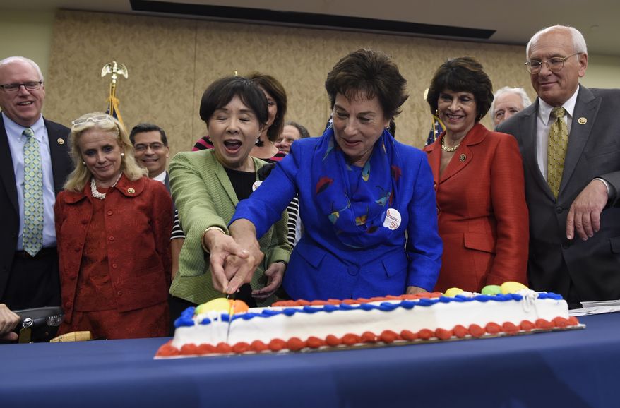 Rep. Doris Matsui, D-Calif, in green, and Rep. Jan Schakowsky, D-Ill., in blue, cut a cake to celebrate the 50th anniversary of Medicare and Medicaid on Capitol Hill in Washington on July 29, 2015. They are joined by Rep. Joe Crowley, D-N.Y., left, Rep. Debbie Dingell, D-Mich., second from left, Rep. Xavier Becerra, D-Calif., third from left, and Rep. Paul Tonko, D-N.Y., right. (AP Photo/Susan Walsh)