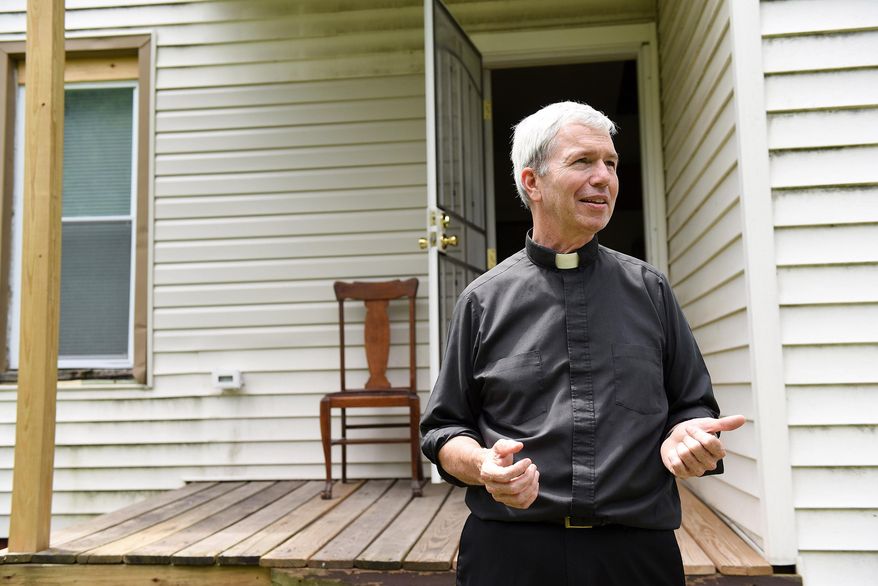 Monsignor Daniel Trapp from St. Augustine and St. Monica Catholic Church talks about this home that was purchased and renovated nearby the church in Detroit on July 20, 2015. Trapp is on a mission to beautify the neighborhood that surrounds his church on Detroit's east side, where he has worked for 20 years. (Robin Buckson/Detroit News via AP) DETROIT FREE PRESS OUT; HUFFINGTON POST OUT; MANDATORY CREDIT