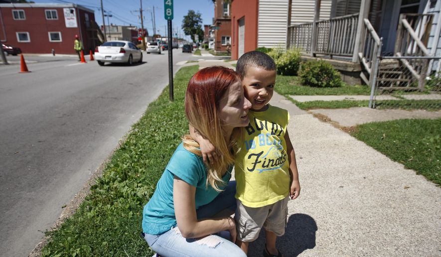 This July 29, 2015 photo shows Becca Webster with her son, O.J. in Dubuque, Iowa. Webster lives near where shots were fired in downtown Dubuque on Tuesday, and isn't fazed by the increase in gunfire. She said she still regularly enjoys walks with her son. (Mike Burley/Telegraph Herald via AP)