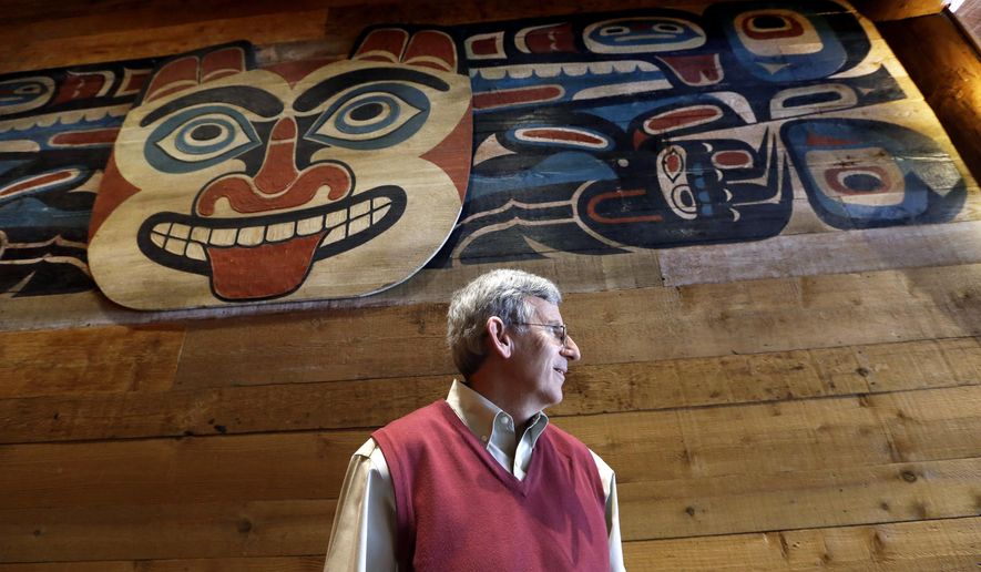 In this photo taken Monday, July 27, 2015, Bob Donegan, president of Ivar’s Seafood Restaurants, stands below a Native American artwork in one of the company's restaurants in Seattle. After Seattle's new minimum wage law took effect last April 1, Ivar’s announced that it was jacking up its prices by about 21 percent, eliminating tipping as a routine procedure, and immediately paying all its hourly workers a $15 per hour. They began the new pay rate three years earlier than the law required. (AP Photo/Elaine Thompson)