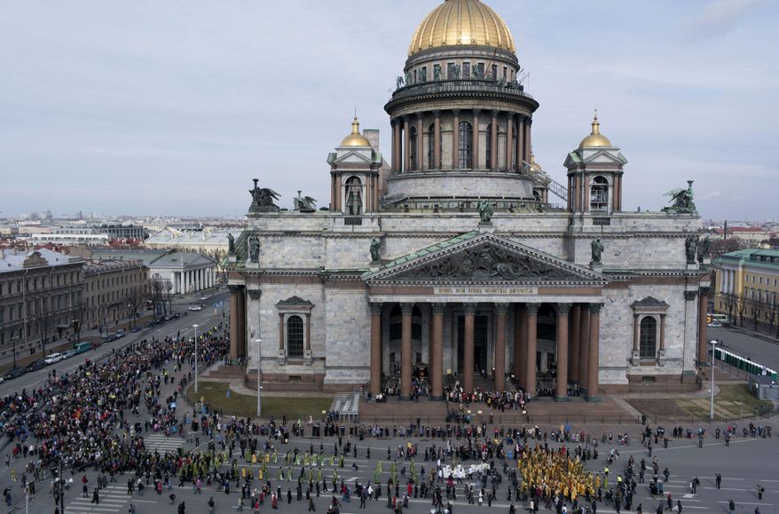 FILE - In this file aerial photo taken on Sunday, April 13, 2014, Orthodox priests and believers participate in the Palm Sunday procession around the St. Isaak's Cathedral in St. Petersburg, Russia. The Russian Orthodox Church on Friday defended its controversial bid to fully take over St. Petersburg's landmark St. Isaac's Cathedral, saying it's in line with the law and wouldn't hamper tourist access. (AP Photo/Dmitry Lovetsky, file)