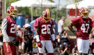 Washington Redskins cornerback Bashaud Breeland (26), center, defensive back Jeron Johnson, left, and defensive back Akeem Davis go through offensive drills during an NFL football training camp in Richmond, Va., Friday, July 31, 2015. Breeland was suspended Friday by the NFL for violating the leagues substance abuse policy. (AP Photo/Jason Hirschfeld)
