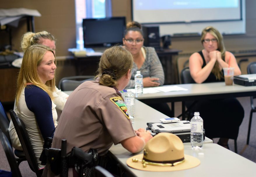 In this July 27, 2015 photo, Trooper Cortney Paul discusses her role as a trooper for the South Dakota Highway Patrol during a recruiting seminar in Sioux Falls, S.D. Paul spoke to a group of women during a seminar hosted by the patrol in an effort to bring more women onto the force, which currently only has five active female troopers. (AP Photo/Kevin Burbach)
