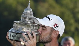 Troy Merritt kisses the trophy after he won the Quicken Loans National golf tournament at the Robert Trent Jones Golf Club in Gainesville, Va., Sunday, Aug. 2, 2015. (AP Photo/Nick Wass)