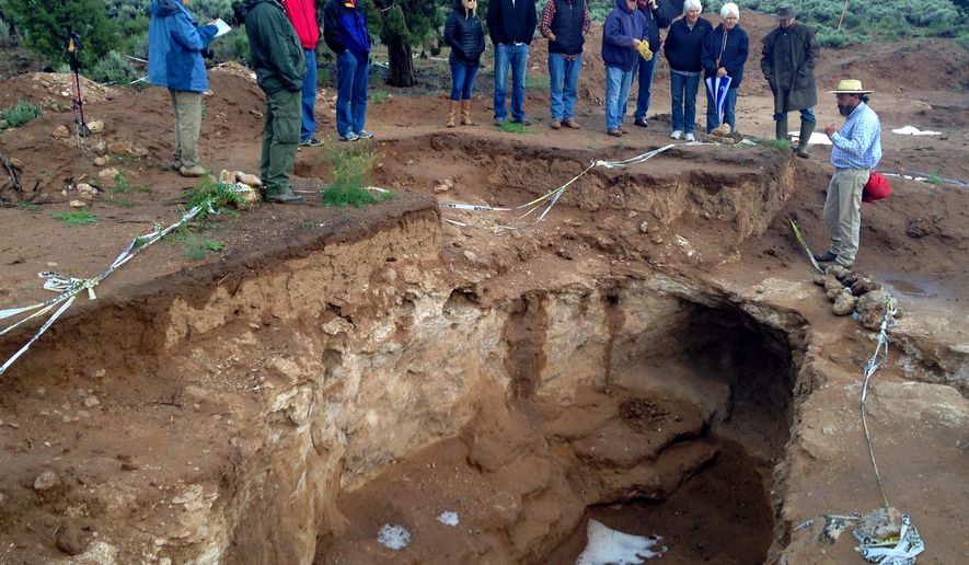 In this May 16, 2015, photo, archaeologist Greg Woodall leads tour showing a archaeological site outside Dammeron Valley, Utah. Archeologists have found evidence of corn farming dating back 1,500 years at the site of an ancient ancestral Puebloan pit house in southern Utah and now they're re-burying it for safe-keeping. (David DeMille/The Spectrum & Daily News, via AP)