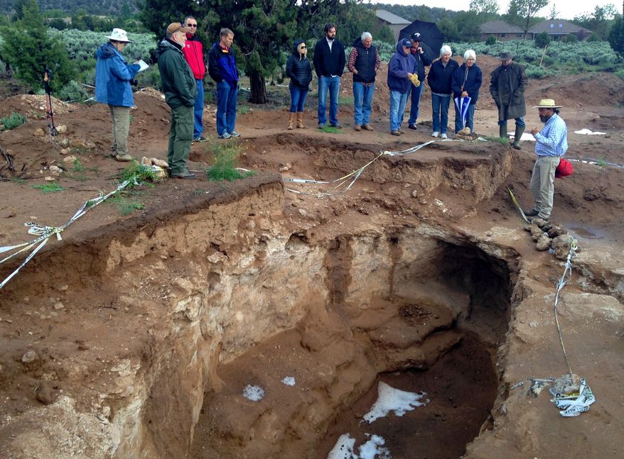 In this May 16, 2015, photo, archaeologist Greg Woodall leads tour showing a archaeological site outside Dammeron Valley, Utah. Archeologists have found evidence of corn farming dating back 1,500 years at the site of an ancient ancestral Puebloan pit house in southern Utah and now they're re-burying it for safe-keeping. (David DeMille/The Spectrum & Daily News, via AP)