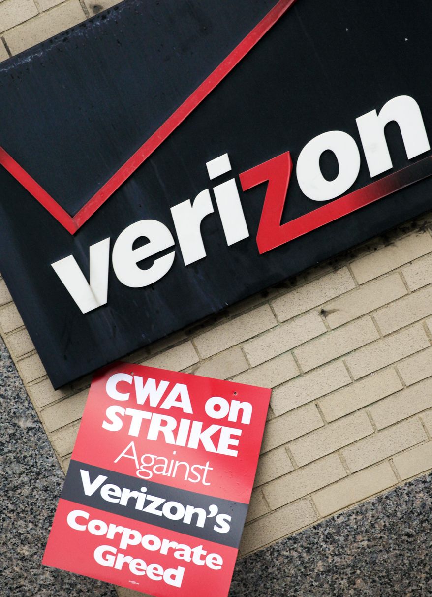 FILE - In this Aug 7, 2011, file photo, a union strike sign hangs below Verizon's corporate logo in front of a facility in New York. Verizon workers in nine states could walk off the job as soon as early Sunday, Aug. 2, 2015, if union negotiators don't reach an agreement over benefits with the wireless carrier. A contract covering 39,000 Verizon workers represented by two unions expires at the end of Saturday, Aug. 1. (AP Photo/Mark Lennihan, File)