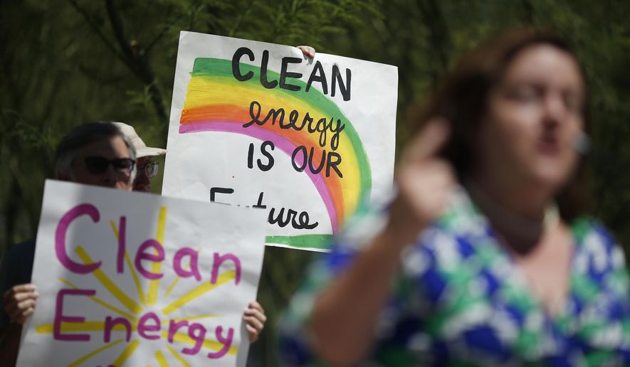 People hold up signs during a news conference in support of the EPA&#x27;s clean power plan, Monday, Aug. 3, 2015, in Las Vegas. (AP Photo/John Locher)
