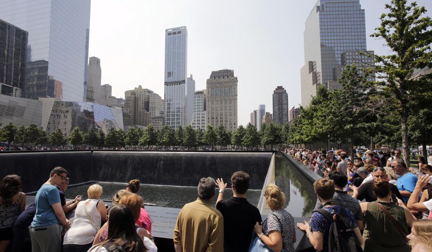 FILE - In this Aug. 8, 2014 file photo, visitors to the Sept. 11 memorial view one of the two reflecting pools in New York. A tourist from Texas was arrested on Saturday Aug. 1, 2015 on charges she was packing two loaded handguns at the Sept. 11 memorial in New York City, authorities said. According to a criminal complaint, Elizabeth Enderli was visiting the site  when she informed a police officer she had the weapons in her backpack. She was charged with criminal possession of a weapon before being released Sunday. Acording to friends, the 31-year-old military veteran has a permit to carry weapons in her home state and mistakenly believed the permit covered her visit to New York from the Houston area. (AP Photo/Mark Lennihan, File)