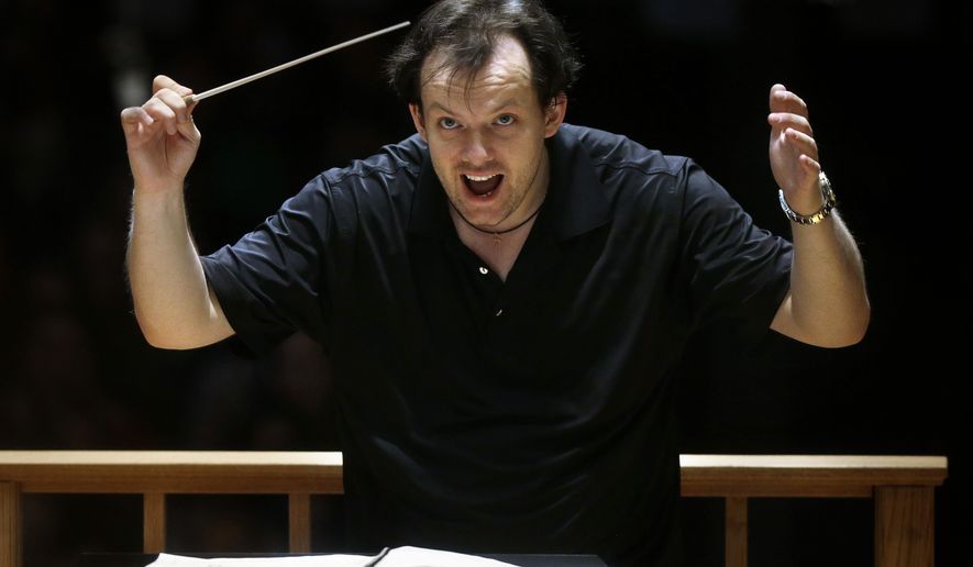 In this Nov. 20, 2014 photo, Boston Symphony Orchestra music director Andris Nelsons rehearses with the orchestra at Symphony Hall in Boston. The Boston Symphony Orchestra is extending Nelsons&#x27; contract, who last year become the orchestra&#x27;s youngest conductor in a century. (AP Photo/Steven Senne)