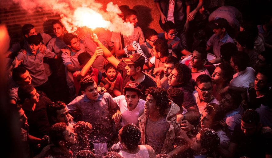 In this Tuesday, June 23, 2015, members of Ultras Nahdawy, a youth group of the Muslim Brotherhood, sing anti-army chants in a protest ahead of the second anniversary of the ouster of Islamist President Mohammed Morsi in the Nahia district, near Cairo, Egypt. Once sympathetic to the Muslim Brotherhood, some among the young protesters now resent it as weak and ineffectual. (AP Photo/Belal Darder)