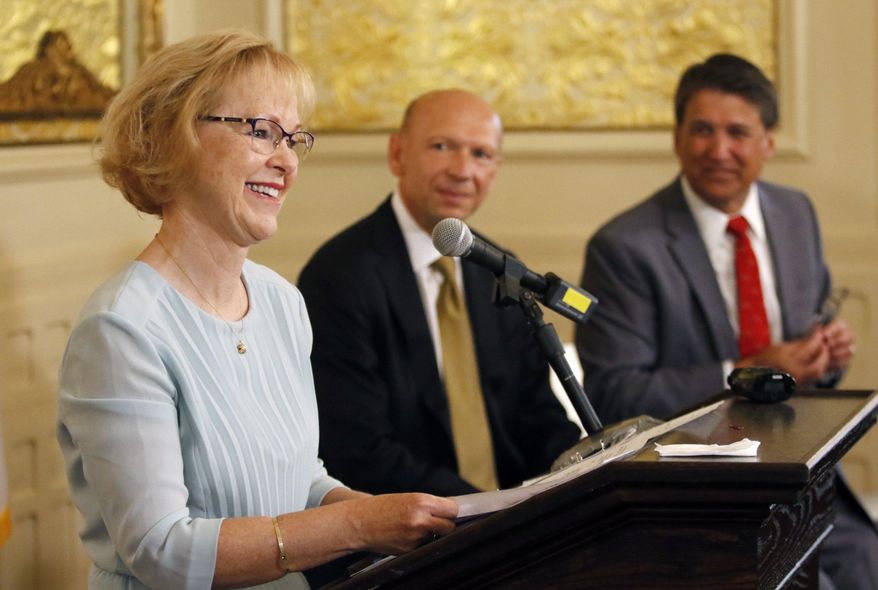 Dr. Aldona Wos, North Carolina's health and human services secretary, thanks her DHHS staffers in the audience for their hard work as Rick Brajer and Gov. Pat McCrory listen during a press conference where she said she was stepping down, Wednesday, Aug. 5, 2015, at the Governor's Mansion in Raleigh, NC. McCrory introduced Brajer as his choice to replace Wos at the emotional ceremony. Wos will remain on the job for two more weeks. (Harry Lynch/The News & Observer via AP) MANDATORY CREDIT