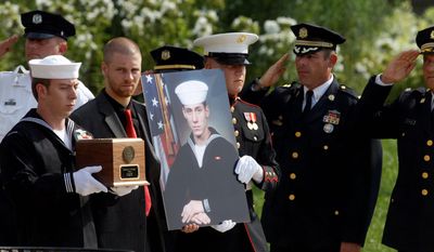 Petty Officer First Class Ian Regnier (above left) carries the remains of Petty Officer 1st Class Michael Joseph Strange, a cryptology technician, killed alongside members of SEAL Team 6 when their helicopter was shot down by a rocket-propelled grenade in Afghanistan in 2011 (bottom). The families of Strange and the other victims are demanding the White House release documents relevant to the incident. (Associated Press)