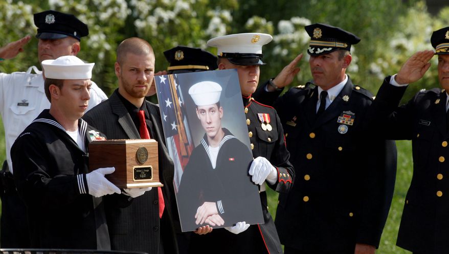 Petty Officer First Class Ian Regnier (above left) carries the remains of Petty Officer 1st Class Michael Joseph Strange, a cryptology technician, killed alongside members of SEAL Team 6 when their helicopter was shot down by a rocket-propelled grenade in Afghanistan in 2011 (bottom). The families of Strange and the other victims are demanding the White House release documents relevant to the incident. (Associated Press)