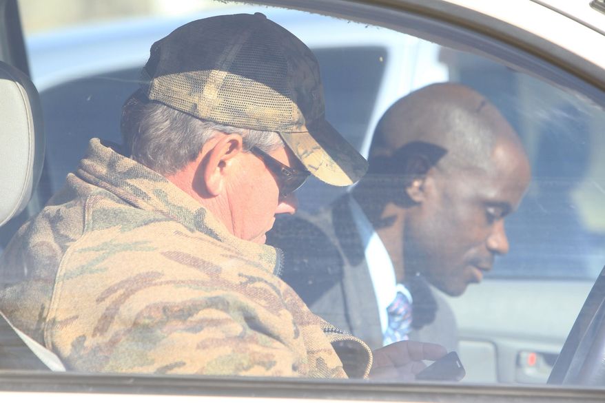 Professional hunter Theodore Bronkhorst is seen in his car with his lawyer Givemore Muvhiringi, back, upon their arrival at the magistrates courts to face trial in Hwange about 700 kilometres south west of Harare, Zimbabwe, Wednesday, Aug. 5, 2015. The trial of a professional hunter who helped an American kill a popular lion named Cecil in an allegedly illegal hunt in Zimbabwe has been postponed to Sept. 28. Theo Bronkhorst appeared Wednesday in a court in Hwange town, where he faces charges of failing to prevent an unlawful hunt. If convicted, he faces up to 15 years in prison. (AP Photo/Tsvangirayi Mukwazhi)