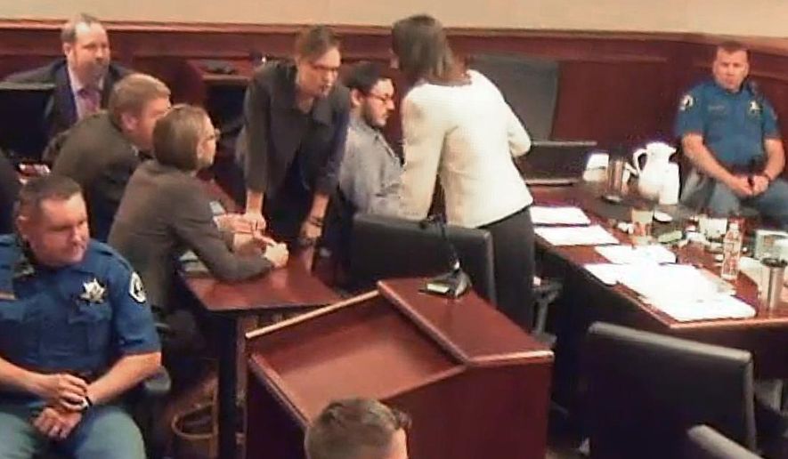 In this image taken from video provided by the Colorado Judicial Department, Colorado theater shooter James Holmes sits, center sixth from left in a gray shirt, as members of his defense team lean above him discussing an issue during Holmes' trial, in Centennial, Colo., Wednesday, Aug. 5, 2015. The Holmes jury are hearing more heart-wrenching testimony from those who lost loved ones in the attack, as prosecutors begin their final push to have James Holmes sentenced to death. (Colorado Judicial Department via AP, Pool)