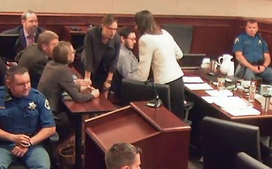 In this image taken from video provided by the Colorado Judicial Department, Colorado theater shooter James Holmes sits, center sixth from left in a gray shirt, as members of his defense team lean above him discussing an issue during Holmes' trial, in Centennial, Colo., Wednesday, Aug. 5, 2015. The Holmes jury are hearing more heart-wrenching testimony from those who lost loved ones in the attack, as prosecutors begin their final push to have James Holmes sentenced to death. (Colorado Judicial Department via AP, Pool)