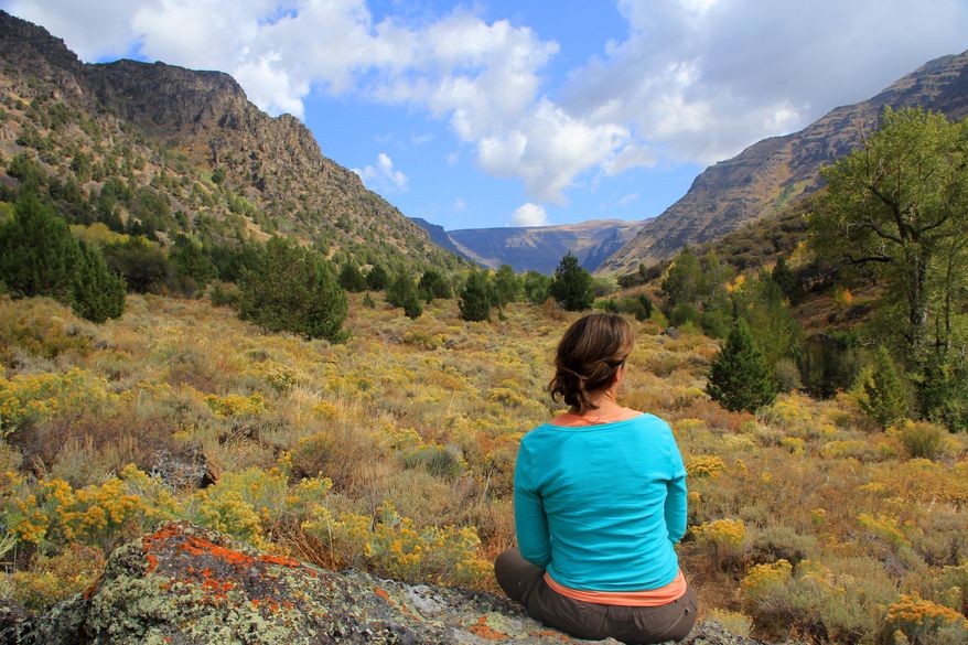 In this May 16, 2010, a woman sits at Big Indian Gorge by Steens Mountain in Oregon. The best way to experience these wild and beautiful mountains is with a backpacking trip. (Zach Urness/Statesman Journal via AP)