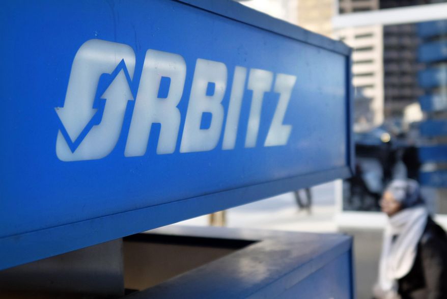 FILE - This Feb. 12, 2015 file photo shows signage for travel booking site Orbitz outside the building that houses its headquarters, in Chicago. The American Hotel & Lodging Association on Thursday, Aug. 6, 2015 issued a statement announcing its opposition to the proposed combination of travel booking sites Expedia and Orbitz, saying that the deal would mean higher prices for vacationers and larger fees for hotel owners. (AP Photo/Kiichiro Sato, File)