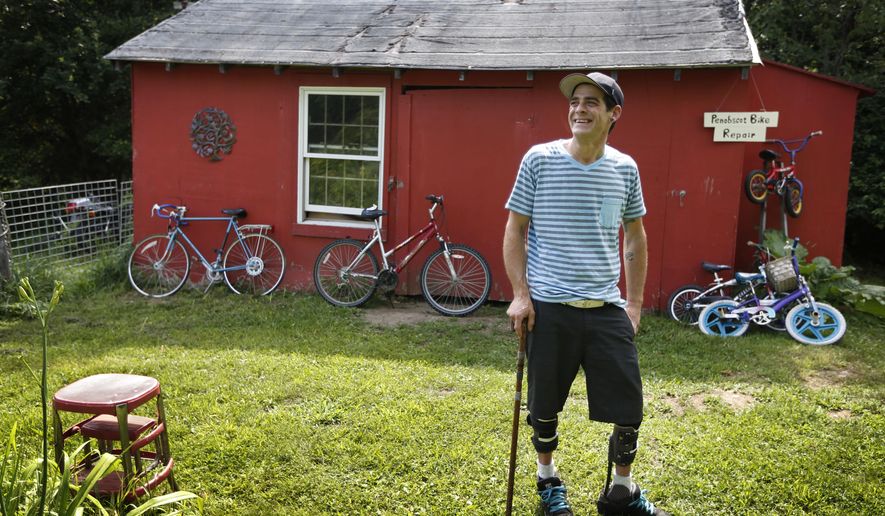 In Thursday, July 30, 2015 photo Ryan Kinsella poses outside his bicycle repair business in Penobscot, Maine. Kinsella broke his back in a rock climbing accident in 2002. The accident left him with partially paralyzed legs. He is recovering from a long battle with hepatitis C., which he contracted by sharing IV drug needles. The rise of cheap heroin has brought a rise in hepatitis C. Perhaps nowhere is the problem starker than in Downeast Maine, which has the highest hepatitis C rate in a state with quintuple the national average. (AP Photo/Robert F. Bukaty)