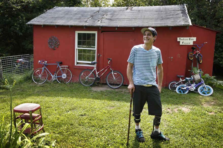 In Thursday, July 30, 2015 photo Ryan Kinsella poses outside his bicycle repair business in Penobscot, Maine. Kinsella broke his back in a rock climbing accident in 2002. The accident left him with partially paralyzed legs. He is recovering from a long battle with hepatitis C., which he contracted by sharing IV drug needles. The rise of cheap heroin has brought a rise in hepatitis C. Perhaps nowhere is the problem starker than in Downeast Maine, which has the highest hepatitis C rate in a state with quintuple the national average. (AP Photo/Robert F. Bukaty)