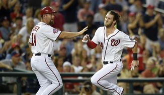 Washington Nationals&#39; Bryce Harper, right, runs past third base coach Bob Henley, left, on his way home to score on a double by Ryan Zimmerman during the fourth inning of a baseball game, Friday, Aug. 7, 2015, in Washington. (AP Photo/Nick Wass) **FILE**