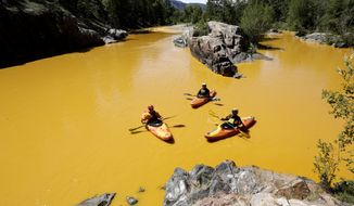 People kayak in the Animas River near Durango, Colo., on Aug. 6, 2015, in water colored from a mine waste spill. The U.S. Environmental Protection Agency said that a cleanup team was working with heavy equipment Wednesday to secure an entrance to the Gold King Mine. Workers instead released an estimated 1 million gallons of mine waste into Cement Creek, which flows into the Animas River. (Jerry McBride/The Durango Herald via Associated Press)