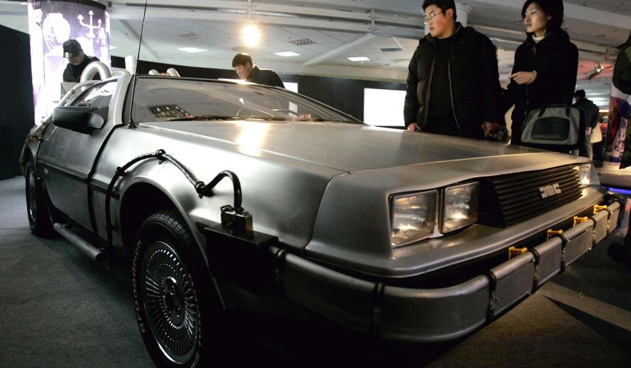FILE - In this Saturday, March 5, 2005, file photo, visitors look at a Delorean used in the U.S. movie "Back to the Future," at International Classic Cars China Tour 2005 in Shanghai. A settlement in a lawsuit over the car used in the 1985 film "Back to the Future" has hit a snag. In 2014, the widow of automaker John DeLorean sued a Texas company she said has been illegally using the DeLorean name for years. The two sides in the lawsuit reached a preliminary settlement in June 2015, that would pay an undisclosed amount of money to Sally DeLorean, but her attorney has written a letter to the judge alleging the company's lawyers were trying to change the settlement at the last minute. (AP Photo/Eugene Hoshiko, File)