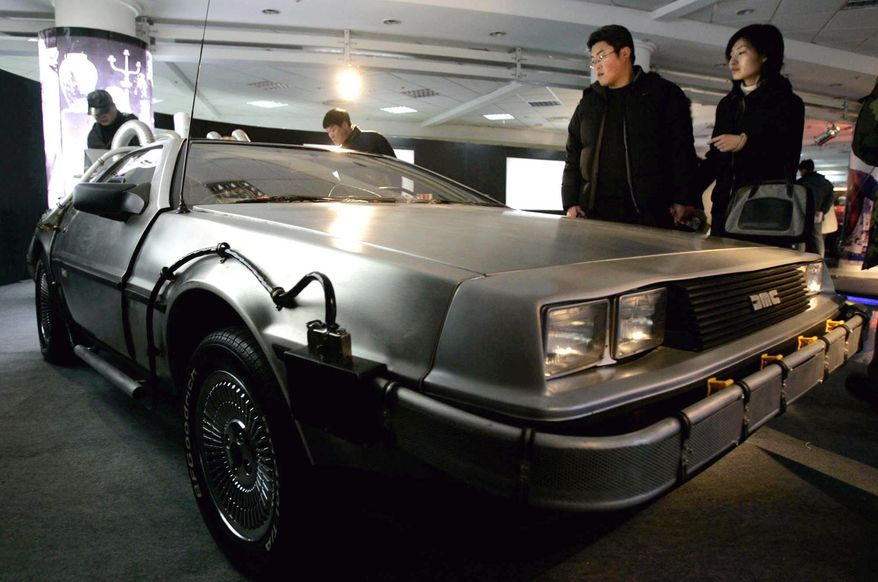 FILE - In this Saturday, March 5, 2005, file photo, visitors look at a Delorean used in the U.S. movie "Back to the Future," at International Classic Cars China Tour 2005 in Shanghai. A settlement in a lawsuit over the car used in the 1985 film "Back to the Future" has hit a snag. In 2014, the widow of automaker John DeLorean sued a Texas company she said has been illegally using the DeLorean name for years. The two sides in the lawsuit reached a preliminary settlement in June 2015, that would pay an undisclosed amount of money to Sally DeLorean, but her attorney has written a letter to the judge alleging the company's lawyers were trying to change the settlement at the last minute. (AP Photo/Eugene Hoshiko, File)