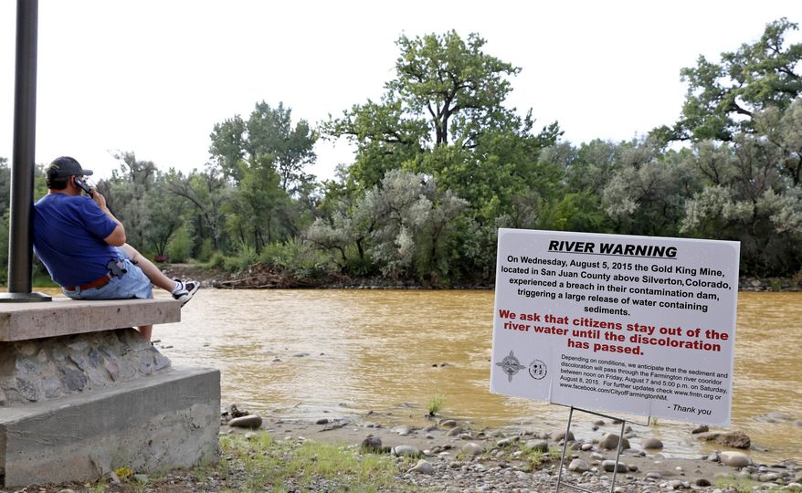 A warning sign from the city is displayed in front of the Animas River as orange sludge from a mine spill upstream flows past Berg Park in Farmington, N.M., on Aug. 8, 2015. About 1 million gallons of wastewater from Colorado's Gold King Mine began spilling into the Animas River on Wednesday when a cleanup crew supervised by the Environmental Protection Agency accidentally breached a debris dam that had formed inside the mine. The mine has been inactive since 1923. (Alexa Rogals/The Daily Times via AP) **FILE**