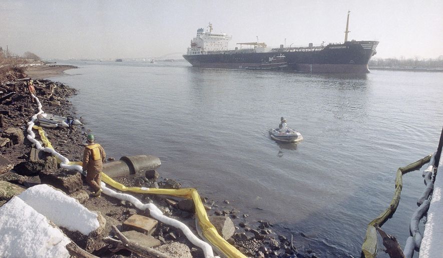 FILE - In this Tuesday, Jan. 9, 1990 file photo, an oil spill cleanup work crew stretches a white absorbent boom line along the shoreline of the Arthur Kill waterway in Elizabeth, N.J. Clean up efforts continue to rid the water of up to 500,000 gallons of No. 2 heating oil believed to have escaped from an underwater Exxon pipeline. New Jersey's 11-year suit against ExxonMobil could result in $50 million in legal fees if a Superior Court judge approves the $225 million proposed settlement. (AP Photo/Mike Derer,file)