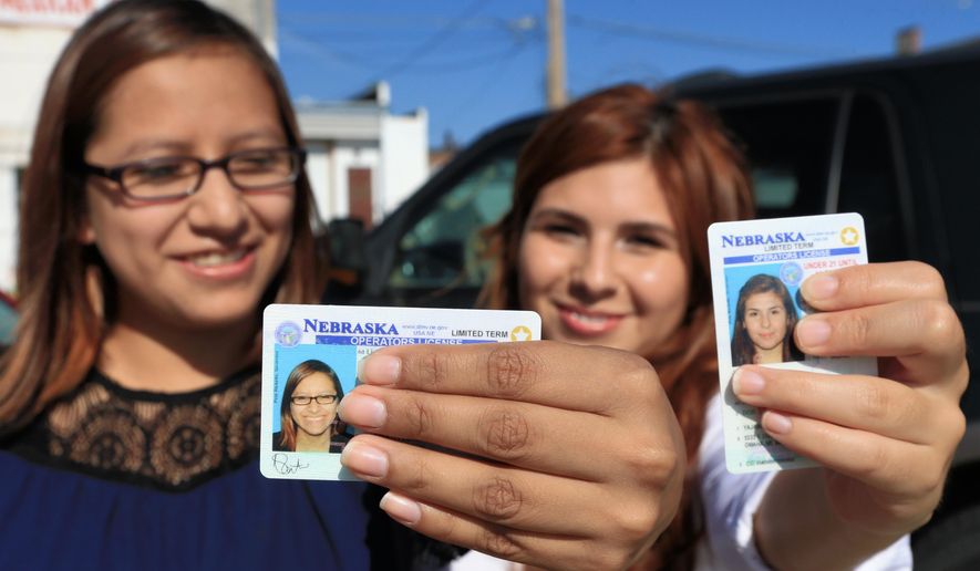 Yajaira Gonzalez, right, a 20-year-old whose parents brought her to Omaha from Mexico shortly before her 9th birthday, and Fatima Flores-Lagunas, 24, a University of Nebraska Omaha junior, pose for a with their drivers licenses in Omaha, Neb., Friday, Aug. 7, 2015. Nebraska has issued 1,300 driver’s licenses to youths who were brought into the country illegally as children since the state became the last in the nation to let them apply. (AP Photo/Nati Harnik)