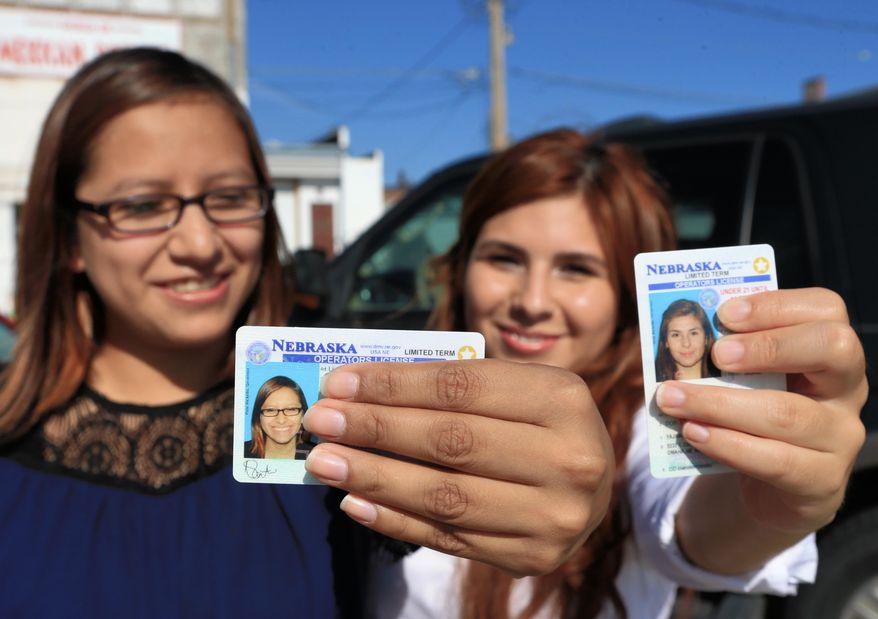 Yajaira Gonzalez, right, a 20-year-old whose parents brought her to Omaha from Mexico shortly before her 9th birthday, and Fatima Flores-Lagunas, 24, a University of Nebraska Omaha junior, pose for a with their drivers licenses in Omaha, Neb., Friday, Aug. 7, 2015. Nebraska has issued 1,300 driver’s licenses to youths who were brought into the country illegally as children since the state became the last in the nation to let them apply. (AP Photo/Nati Harnik)