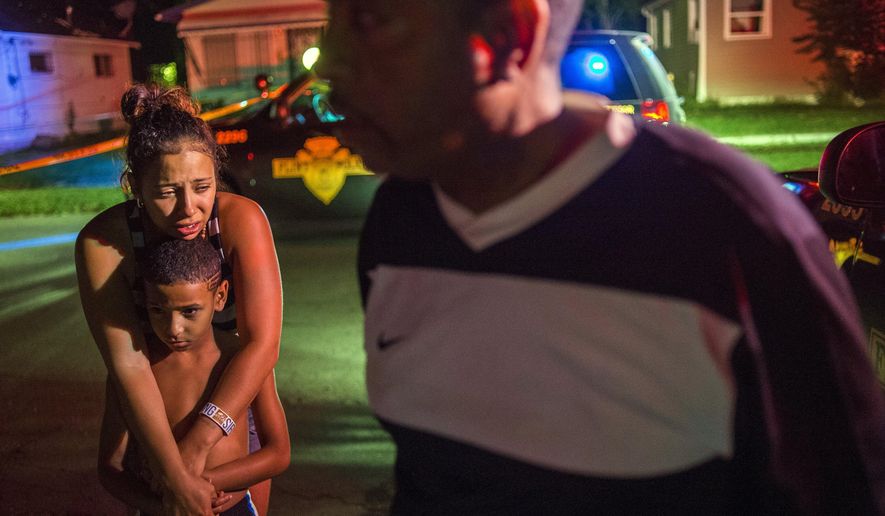 Flint resident Alyssa Tyler, 25, cries as she holds her son James Tyler, 9, after learning of the death of 1-year-old Genesis General Tyler and Rita Langworthy, 70, in a double shooting as Flint Police investigate on Monday morning, Aug. 10, 2015 at the 200 block of West Home Avenue on Flint's north side. Police were called to the scene at 2:24 a.m. The double homicide brings the count to 33 in Flint so far this year. (Jake May/The Flint Journal-MLive.com via AP) LOCAL TELEVISION OUT; LOCAL INTERNET OUT; MANDATORY CREDIT