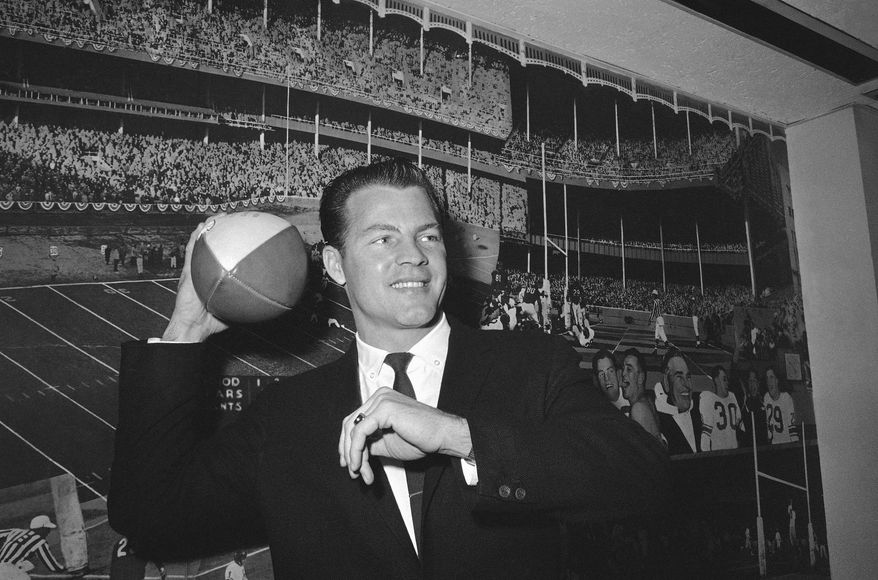 FILE - In this April 2, 1962, file photo, New York Giants halfback Frank Gifford cocks his passing arm as he stands in front of photo mural of the Polo Grounds at the offices of the New York Giants in New York’s Coliseum. In a statement released by NBC News on Sunday, Aug. 9, 2015, his family said Gifford died suddenly at his Connecticut home of natural causes that morning. (AP Photo/John Lindsay, File)