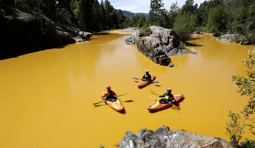 People kayak in the Animas River near Durango, Colo., on Thursday in water discolored by the Gold King Mine waste spill. (Associated Press)