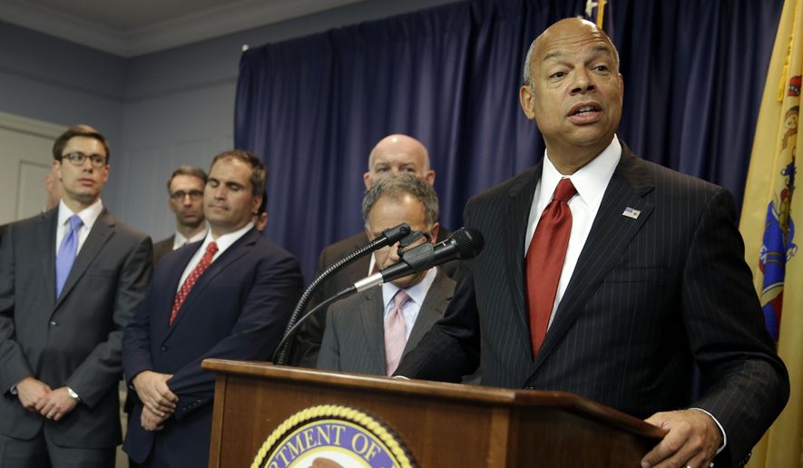 United States Secretary of Homeland Security Jeh Johnson, right, speaks during a news conference in Newark, N.J., Tuesday, Aug. 11, 2015. An international group of hackers and stock traders made $30 million by breaking into the computers of newswire services that put out corporate press releases and trading on the information before it was made public, federal prosecutors said Tuesday. (AP Photo/Seth Wenig)
